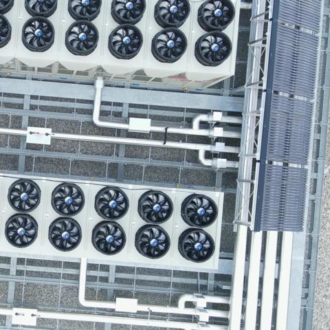 top-down view of a rooftop installation featuring industrial HVAC systems alongside solar panels.