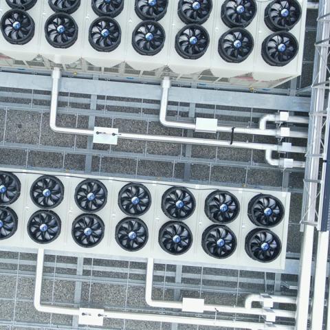top-down view of a rooftop installation featuring industrial HVAC systems alongside solar panels.