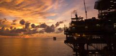 Silhouette of an offshore oil rig at sunset