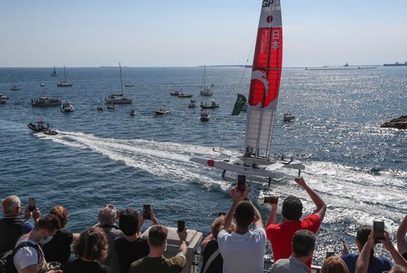 Japan SailGP Team helmed by Nathan Outterridge go past the crowds as they are being towed at pace whilst foiling following a practice session ahead of Italy SailGP, Event 2, Season 2 in Taranto, Italy. 04 June 2021. Photo: Ian Roman for SailGP. Handout image supplied by SailGP