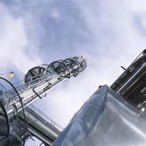 A close-up, low-angle view of the metal framework of an industrial tower or cooling structure against a pale sky.