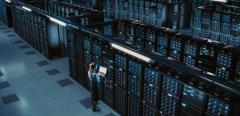 3D Computer Graphics: Data Center Female Chief Technology Officer Using Laptop Standing In Warehouse, Activates Servers, Information Digitalization Starts. SAAS, Cloud Computing, Online Service