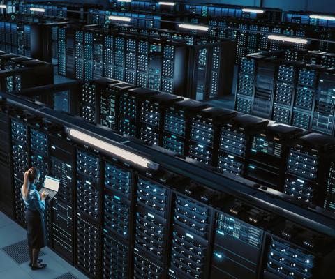 3D Computer Graphics: Data Center Female Chief Technology Officer Using Laptop Standing In Warehouse, Activates Servers, Information Digitalization Starts. SAAS, Cloud Computing, Online Service