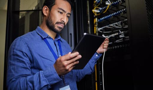 Server room, tablet and engineer with connection cable for maintenance or software update at night. Cybersecurity, it programmer and coder man with technology for database networking in data center