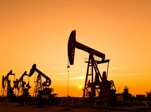 Oil pumps and rig at sunset