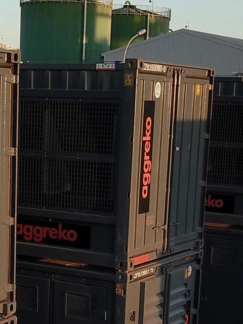 Several Aggreko units stacked on one another at an industrial site.