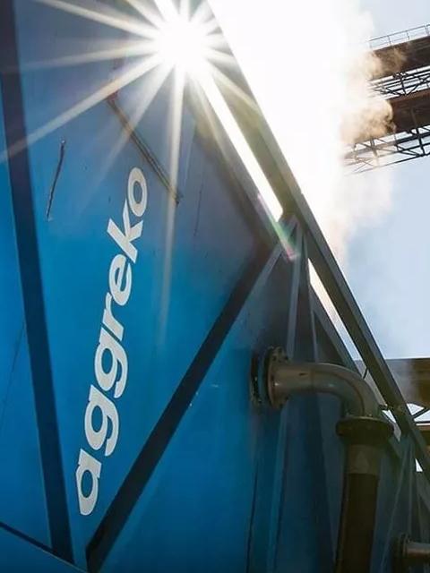 Aggreko equipment at an industrial facility under conveyor structures.