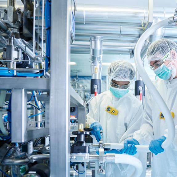 Chemical laboratory technicians fitting hose