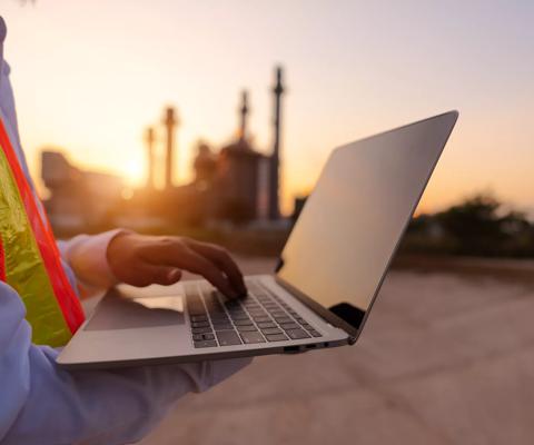 Engineering is use notebook check and standing in front of oil refinery building structure in heavy petrochemical industry