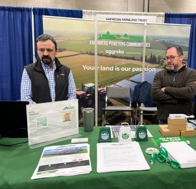 2 men behind a stand at a fair.