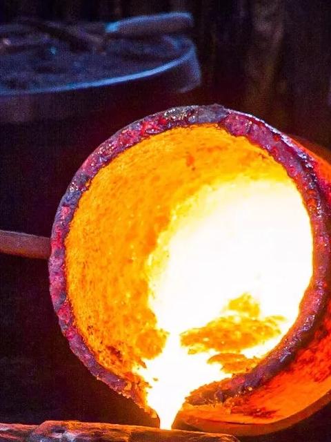Molten metal being poured into a casting mold.