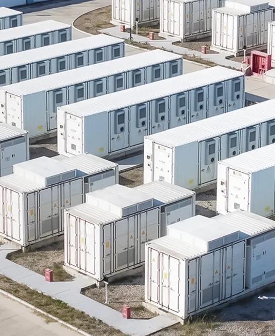 Aerial view of multiple rows of white industrial units outside.