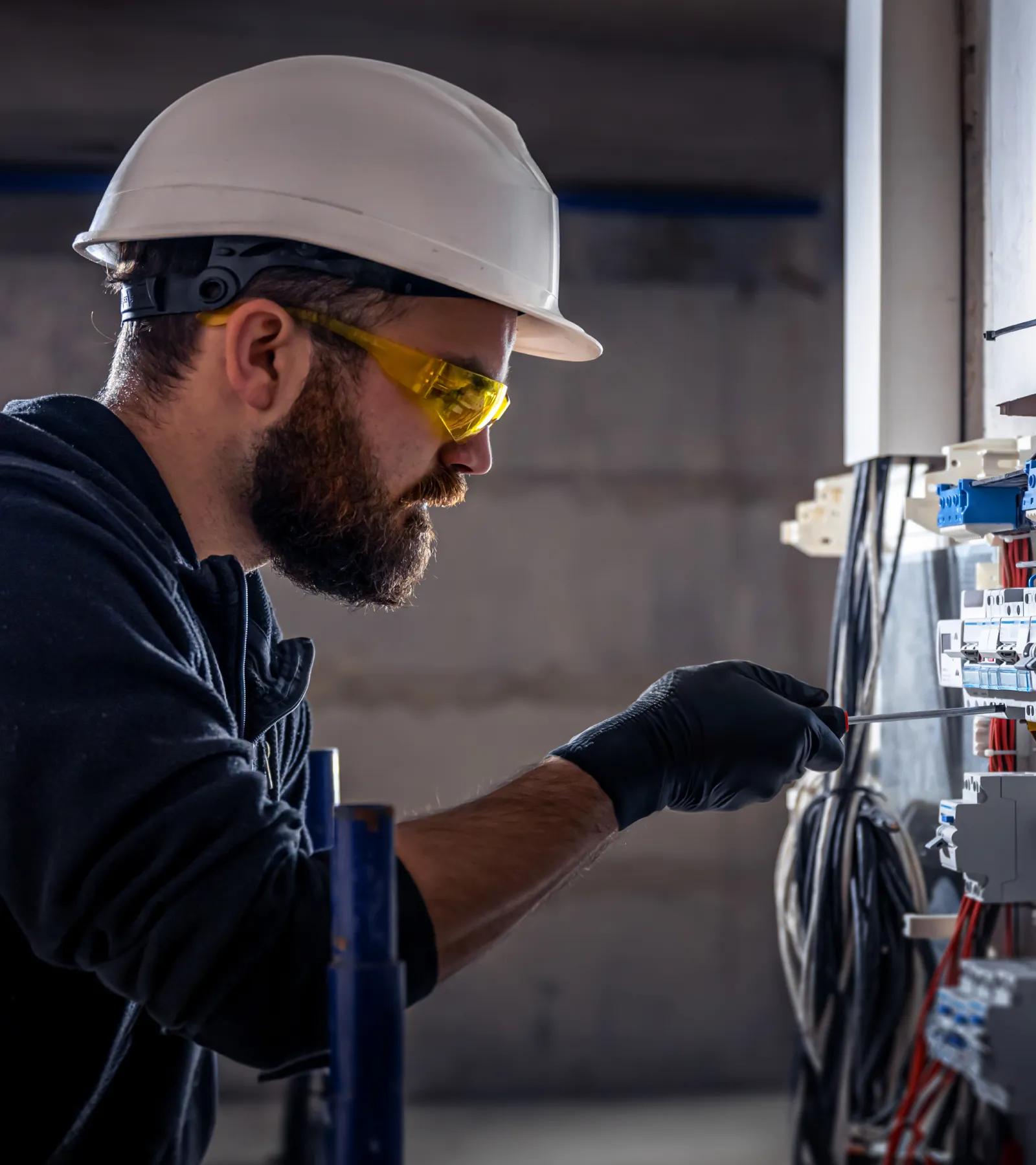 Electrical contractor is shown working on a panel.