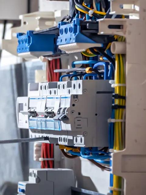 Electrical contractor is shown working on a panel.