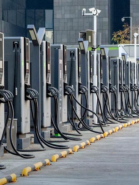 Row of electric vehicle fast charging stations installed outdoors in an urban area