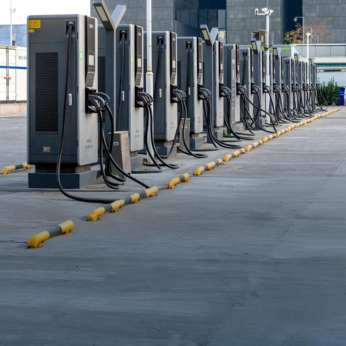 Row of electric vehicle fast charging stations installed outdoors in an urban area