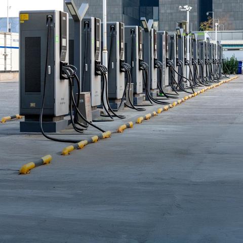 Row of electric vehicle fast charging stations installed outdoors in an urban area