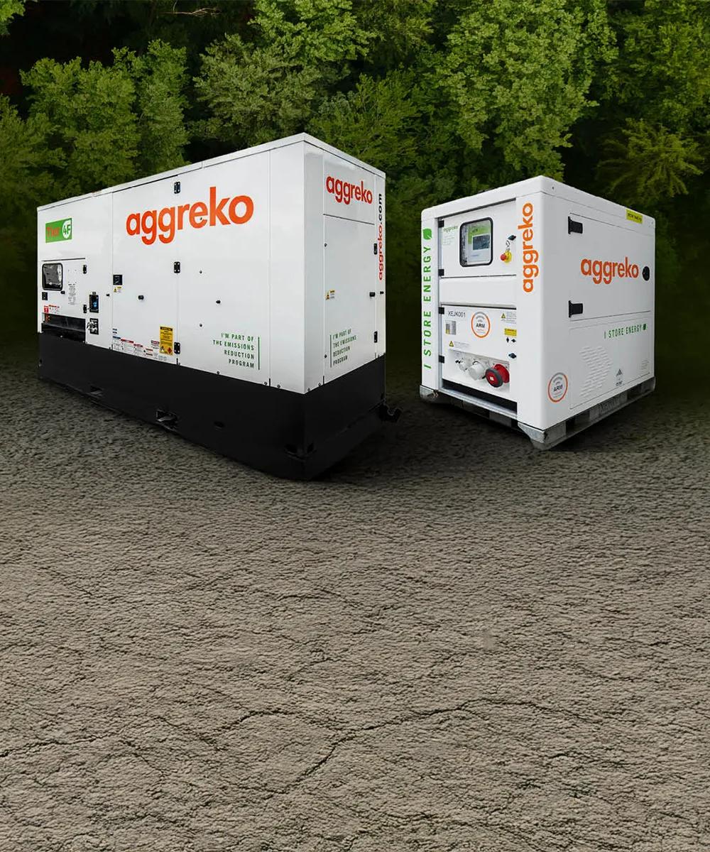Two white Aggreko generators amidst a dense, green forest backdrop.