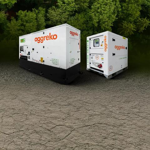 Two white Aggreko generators amidst a dense, green forest backdrop.