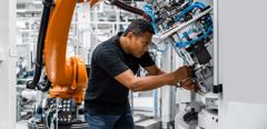 Engineer examining robotic arm in factory