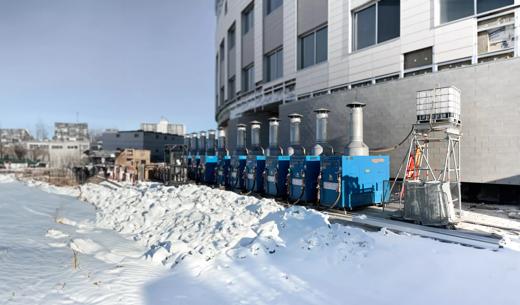 Row of heaters in the snow in front of medical facility