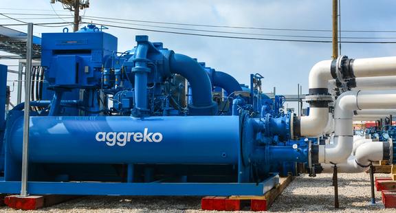 Une grande unité industrielle bleue Aggreko à l’extérieur sur un site industriel.