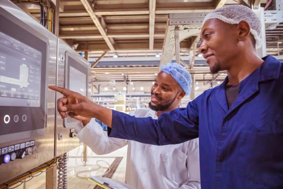 African / Zambian Factory Workers monitoring Electrical Panel in Beverages Factory Factory