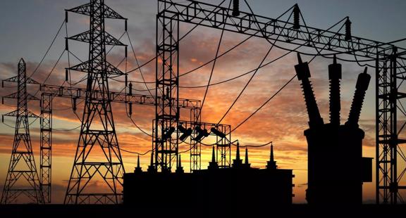 Electric plant in the shadows against an orange sunset.