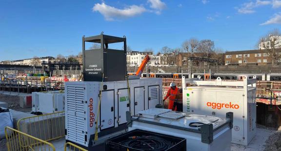 Vue de deux travailleurs en uniforme s'occupant de plusieurs groupes électrogènes en coulisses.