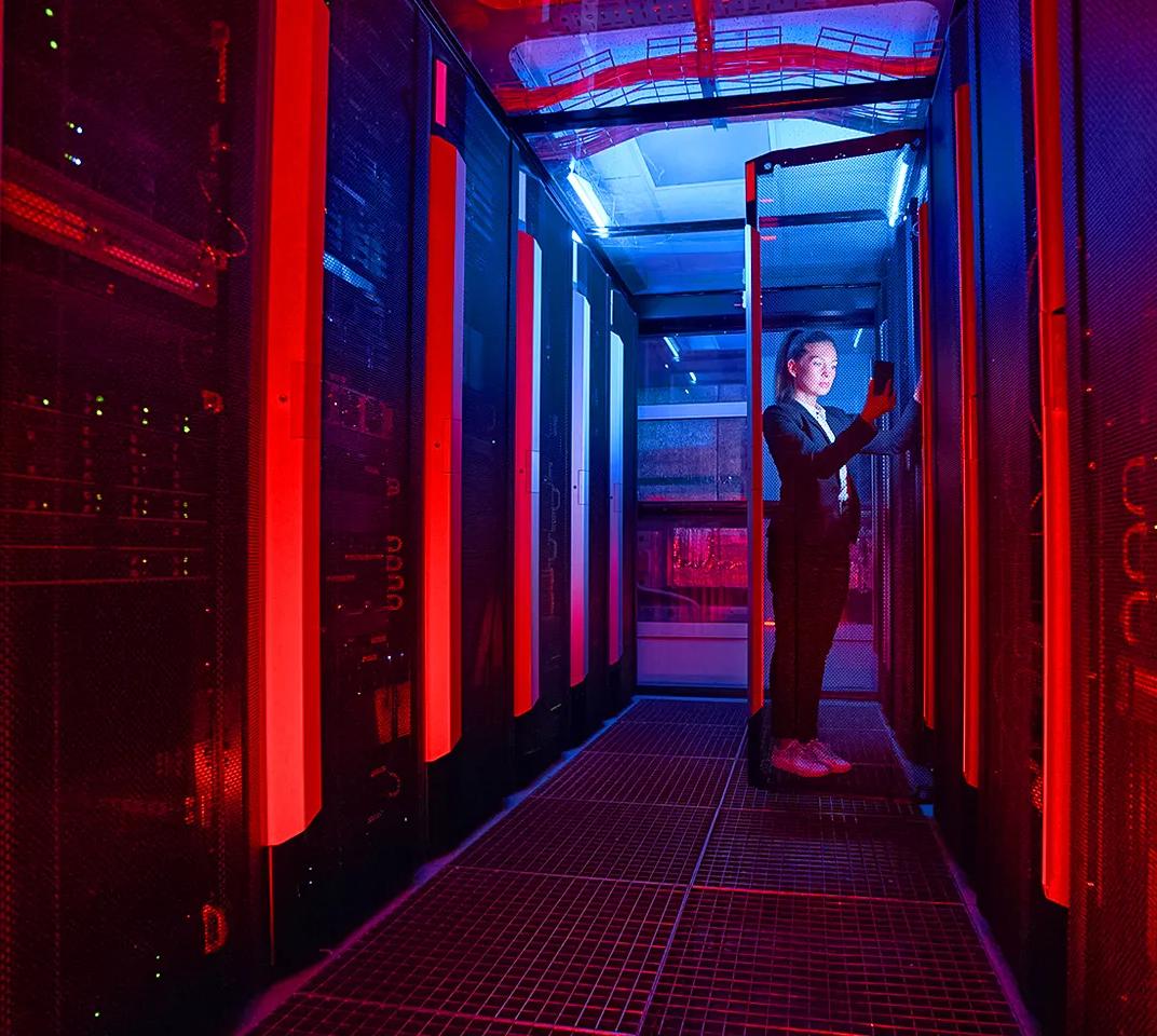 Couloir sombre de serveurs à l’intérieur d’un centre de données avec éclairage rouge 