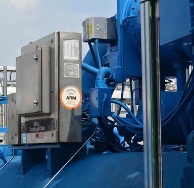 A gray industrial tank with the logo "Aggreko" on it, part of a larger machinery setup, featuring pipes and control panels.