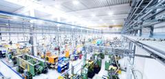 Horizontal high angle view color image of futuristic factory. Industrial aisle surrounded by modern machines which having busy robotic arms with molding shapes and producing plastic pieces for variety of industry. Labor intensive production line with manufacturing equipment - boxes, crates, crane, packages, pallets, space for copy