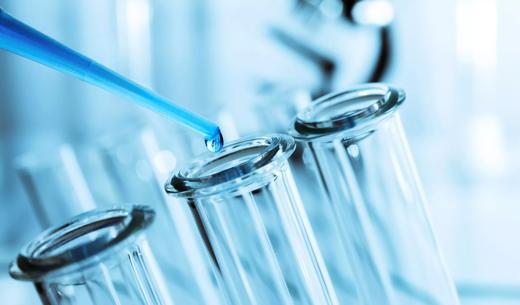 A machine is filling bottles in a vaccine development factory