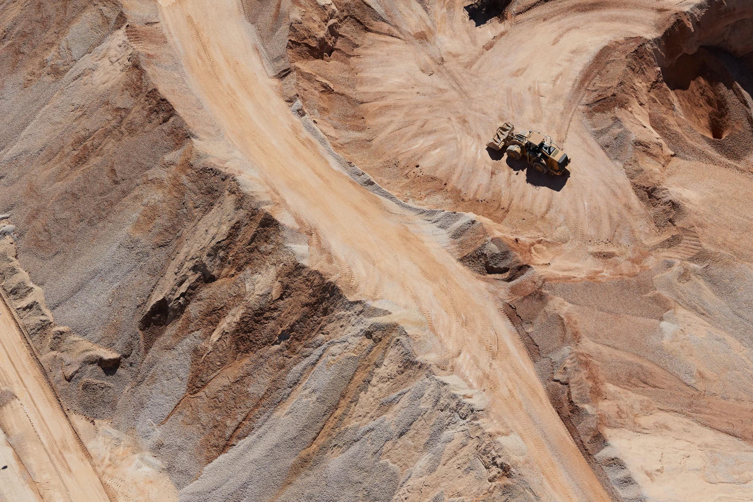 Aerial view of a sand mine's dirt road and a dumper