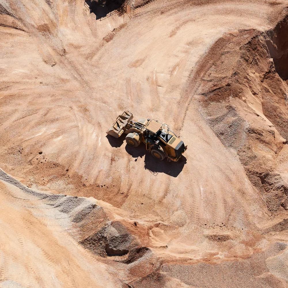 Aerial view of a sand mine's dirt road and a dumper