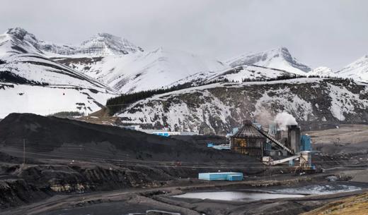 Excavator digging on a snowy mountainside