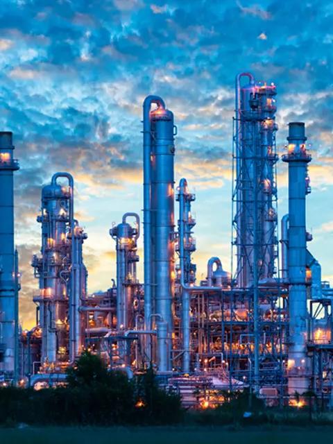 Vue panoramique d'une usine pétrochimique au crépuscule sur fond de ciel nuageux