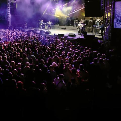 View of people in the general area of a concert watching a band play.