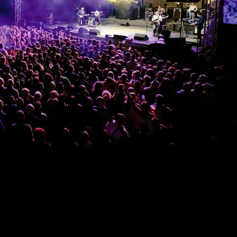 View of people in the general area of a concert watching a band play.