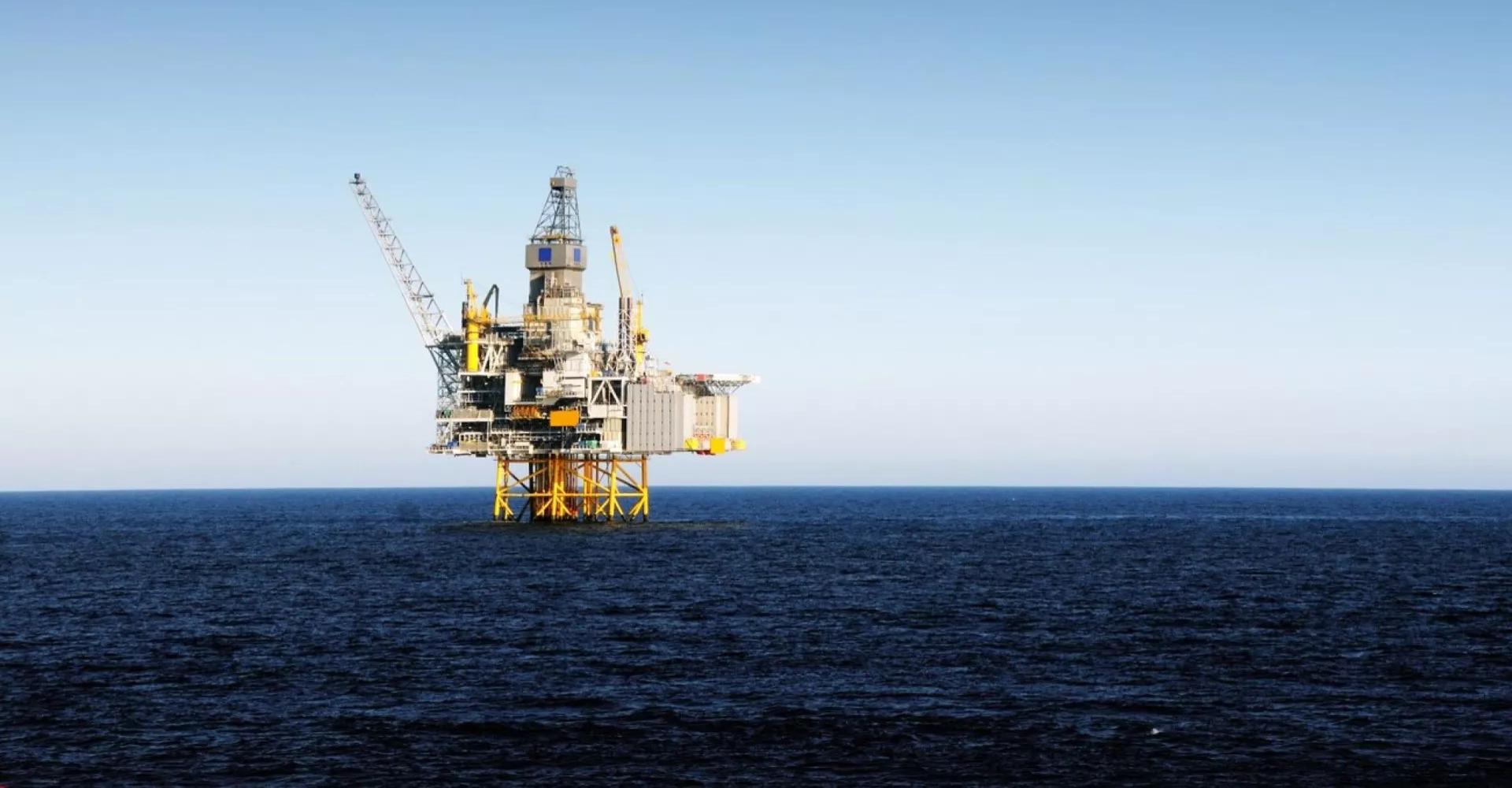 An oil rig in the sea seen from sea level.