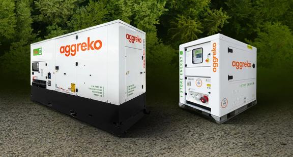 Two Aggreko generator units placed on a gravel surface, surrounded by greenery, showcasing their industrial design.
