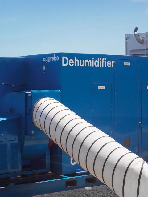 Équipement de déshumidification Aggreko raccordé à de grandes gaines d’air flexibles.
