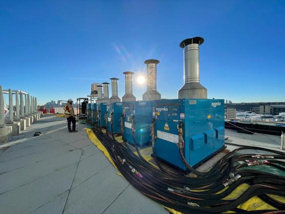 A row of blue Aggreko industrial heaters outside a worksite