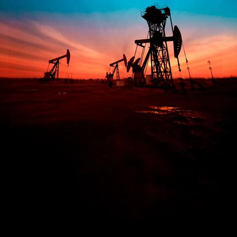 Panoramic view at sunset of four oil rigs on a field