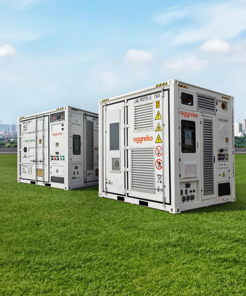 Two white Aggreko generators against each other, with a city view on the background.