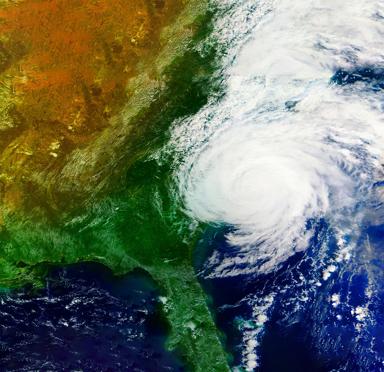 A swirling satellite image of a large hurricane approaching a landmass.