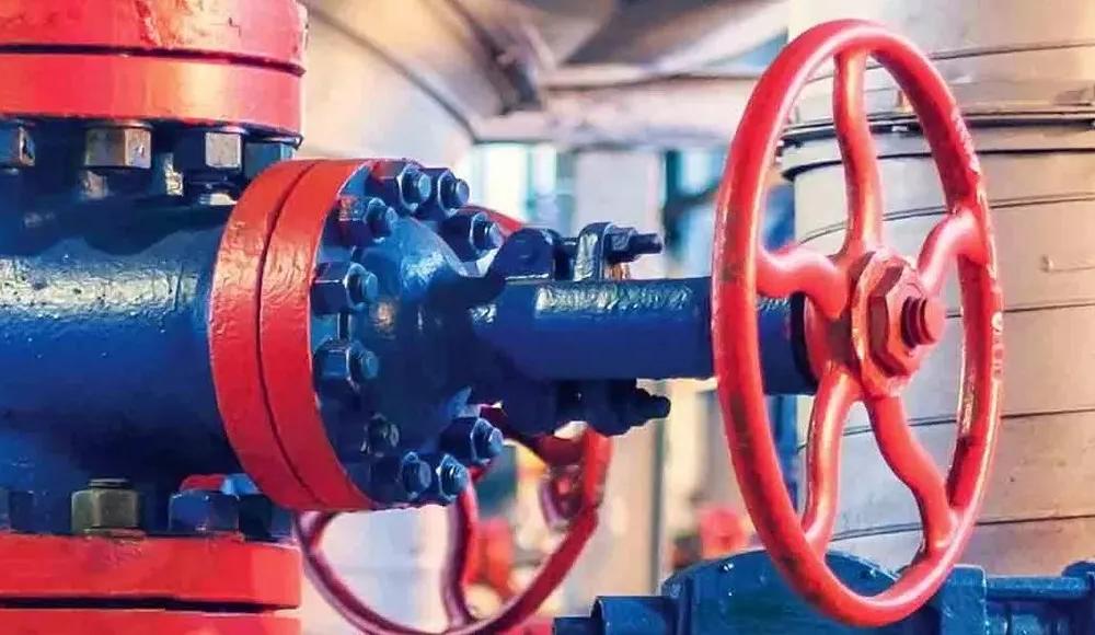 A row of blue and red valves against yellow equipment