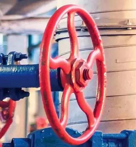 A row of blue and red valves against yellow equipment