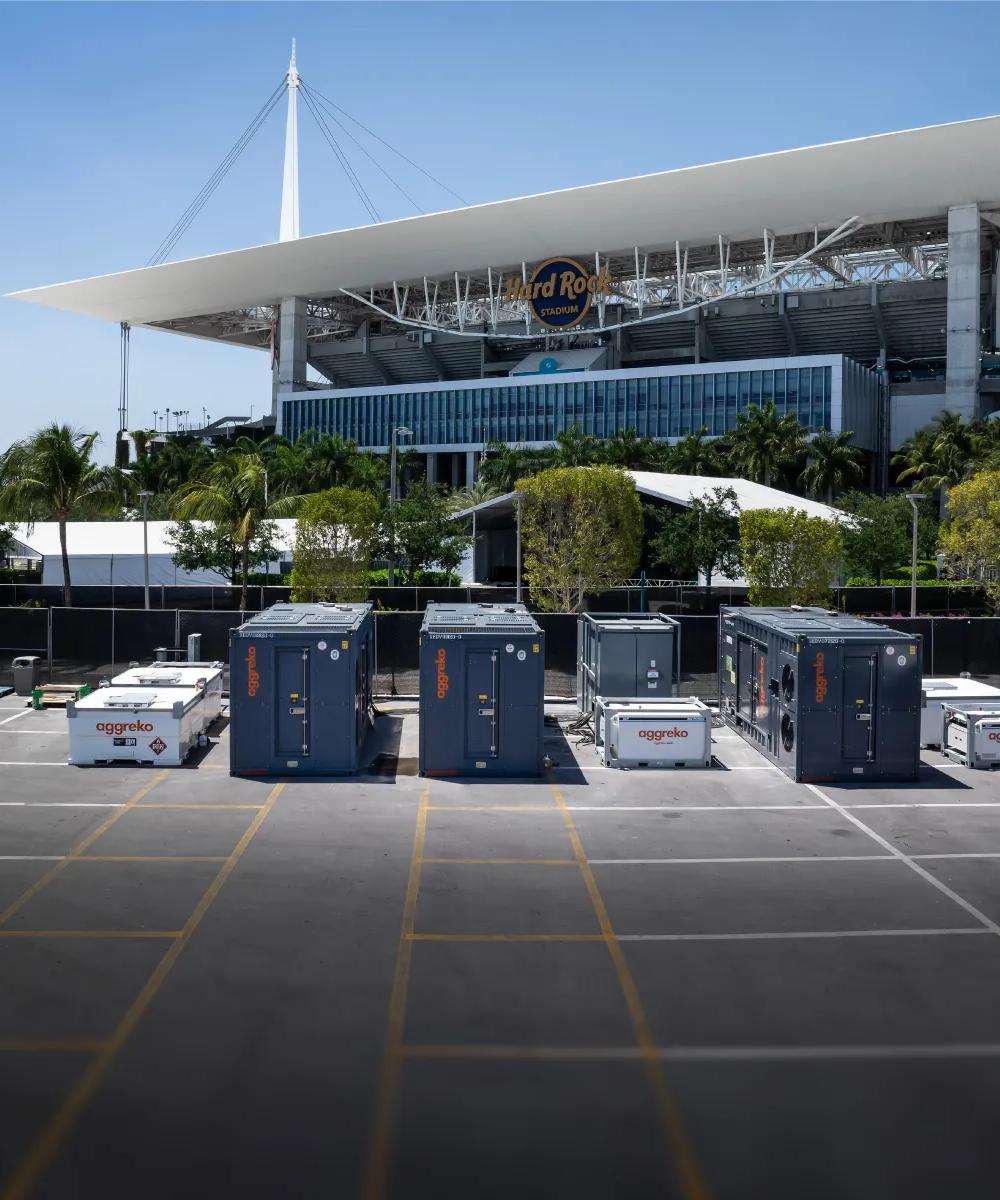 Various  Aggreko power units in a parking lot with Hard Rock Cafe in the back.