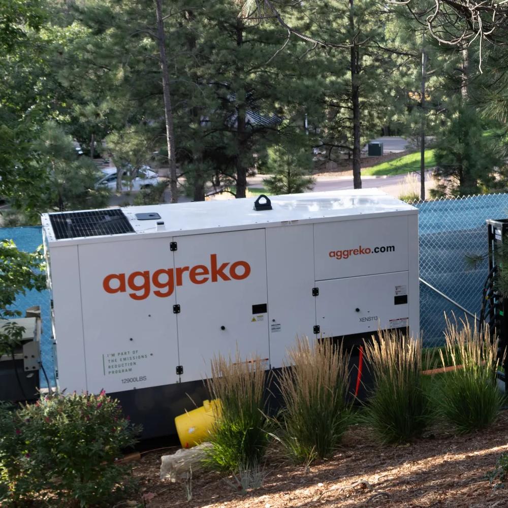 White Aggreko generator outdoors.